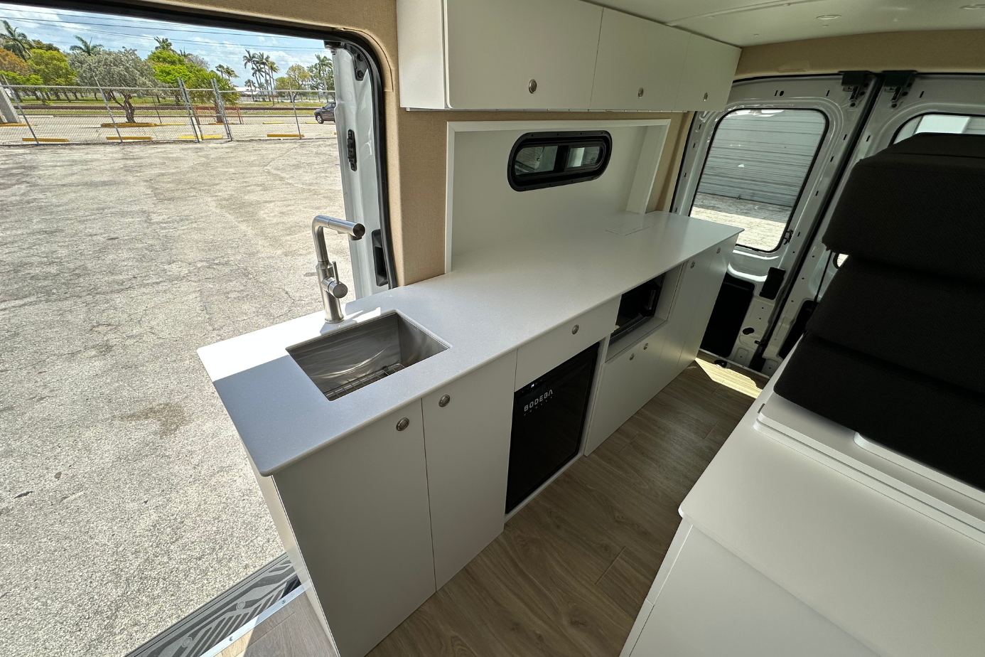 Ford Transit camper van conversion Florida Corian countertop bar sink built in fridge microwave custom van kitchen