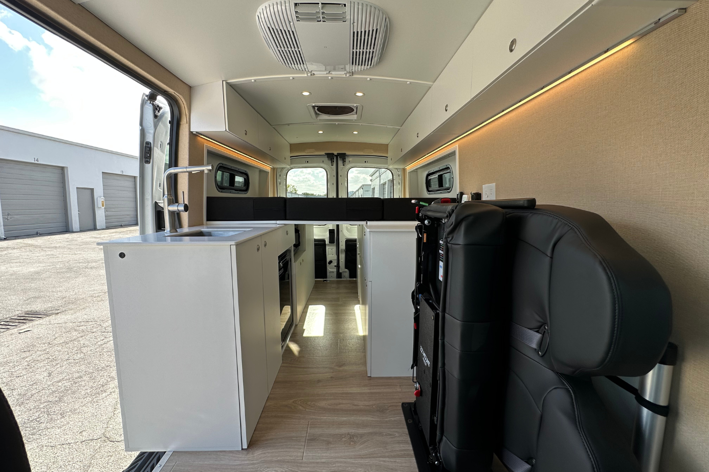 Ford Transit camper van conversion Florida convertible bed platform with LED lighting and hidden foldable passenger seat storage