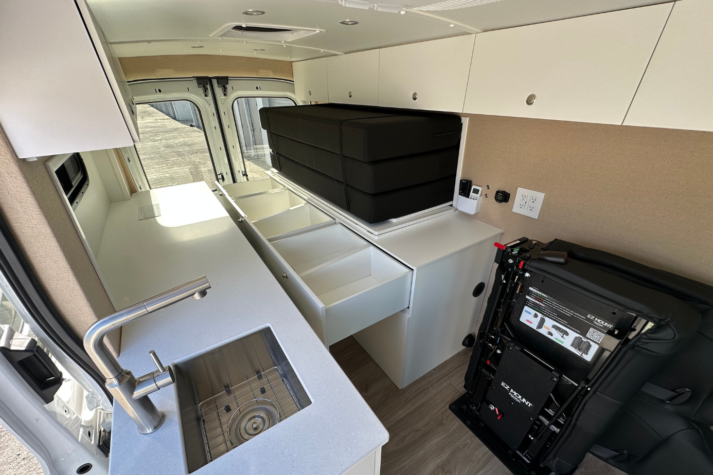 Ford Transit camper van conversion Florida bed folded up with 5 storage drawers under bed custom van build
